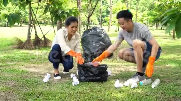 亚洲青年男女在公园的垃圾袋里收集垃圾视频的预览图