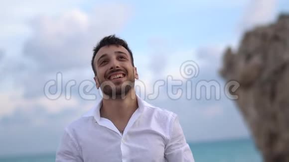 年轻英俊的男子高兴地微笑着带着惊讶的表情向别人挥手塞浦路斯帕福斯视频的预览图