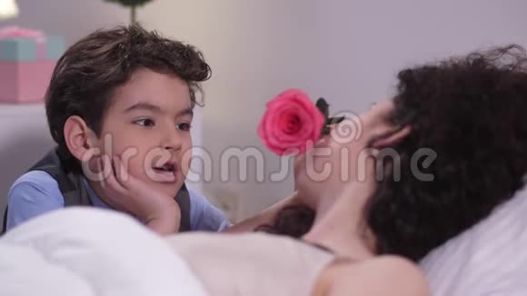 男孩用玫瑰抚摸熟睡妈妈的脸视频的预览图
