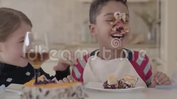 快乐的孩子们边吃蛋糕边玩孩子们在笑非洲裔美国男孩脸上沾满了视频的预览图