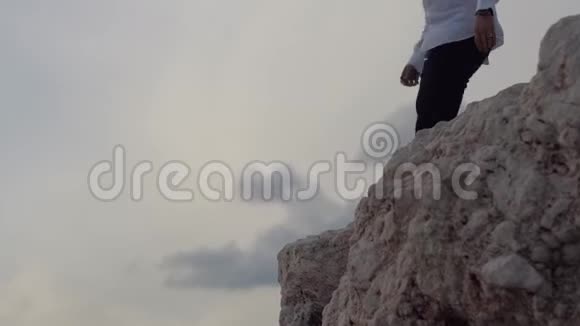年轻人坐在高高的岩石山上欣赏着令人惊叹的海滨景色快乐的家伙大喊大叫吹口哨容容视频的预览图