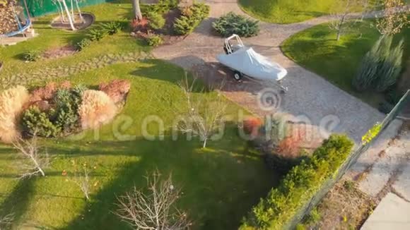 无人驾驶飞机观停在后院花园的拖车上有环形小径绿草如茵的山丘和视频的预览图