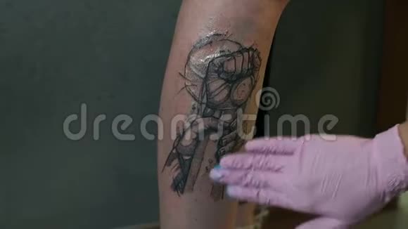 一位纹身艺术家的特写镜头用一种治疗药膏刺激纹身的皮肤视频的预览图