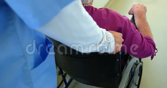 高加索女医生在养老院推轮椅的老年患者4k视频的预览图