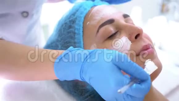 专业美容师和皮肤科医生在美容院用面膜敷脸紧缩和调整程序视频的预览图