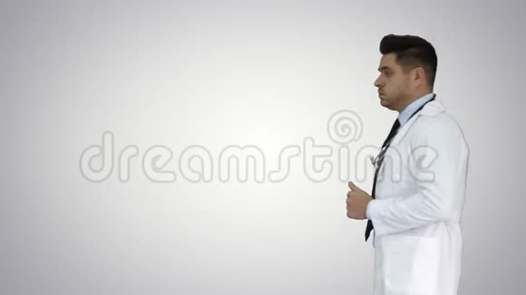 行走的男医生在梯度背景下经过视频的预览图