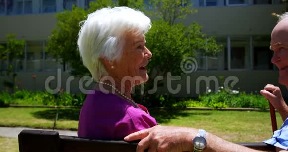 积极的高加索老年夫妇在护理家庭的花园中相互交流的侧视视频的预览图