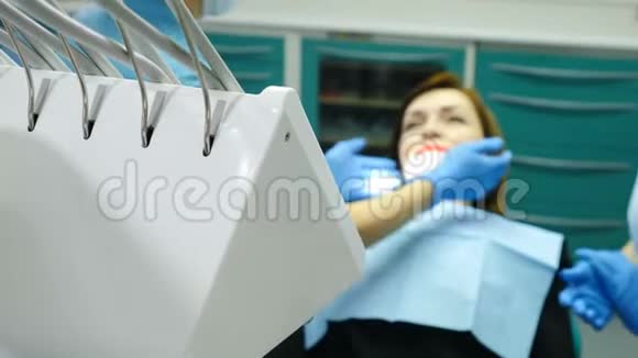 在牙医办公室女性医生治疗的病人在关节上有一些下巴疼痛牙椅上的年轻女子视频的预览图