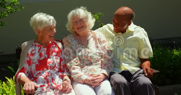 一群活跃的混血高级朋友在养老院的花园里相互交流视频的预览图