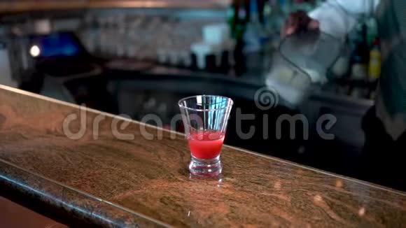酒保把奶油倒入杯子里柜台上有草莓和酒精糖浆熔岩流鸡尾酒视频的预览图