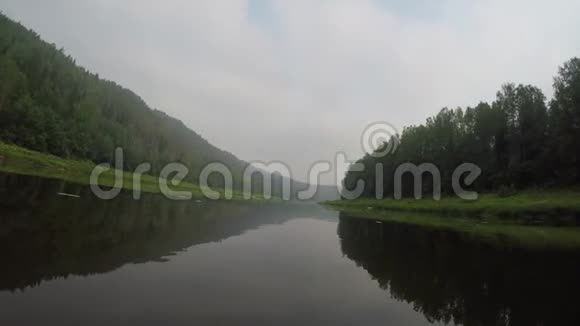 摄像机飞越水面平静和好天气水两岸绿色河岸视频的预览图