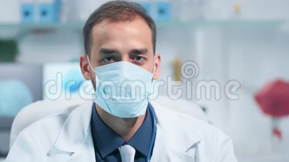 医生戴着药用面具看镜头的肖像视频的预览图