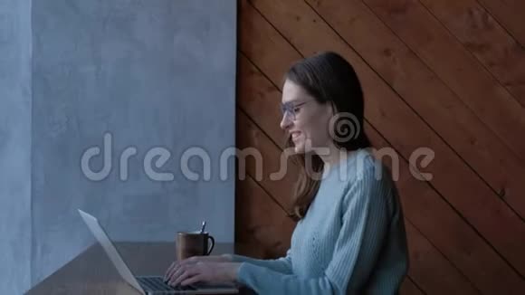 快乐的女人自由职业者在咖啡馆的笔记本上工作视频的预览图