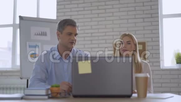 两位成人商业伙伴在办公室的电脑4K工作视频的预览图