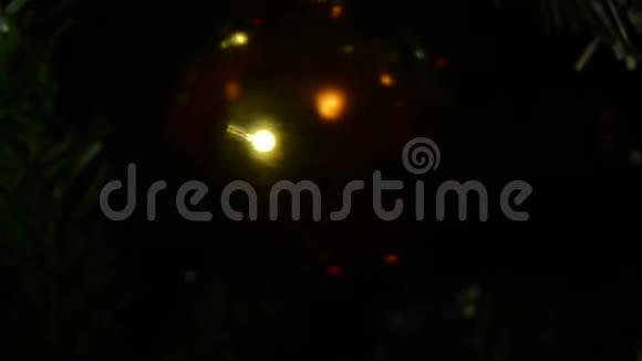 在黑暗的背景上旋转闪闪发亮的圣诞球模糊的背景视频的预览图
