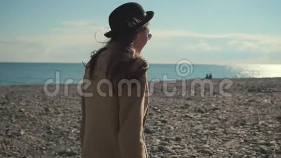 孤独的年轻女子白天在海边漫步侧视和后视视频的预览图