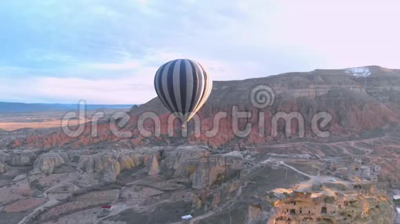 在卡帕多西亚的红色山谷上空飞行的热气球视频的预览图