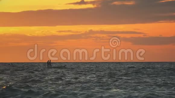 日落时人们乘坐皮艇在海洋中航行视频的预览图