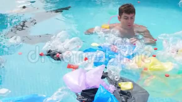 地球污染的概念年轻人在垃圾中游泳视频的预览图