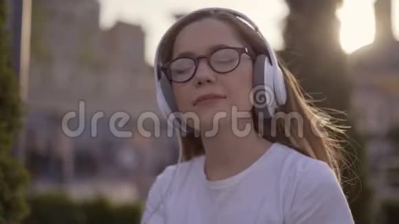 有趣的少女用耳机听音乐用4K唱歌视频的预览图