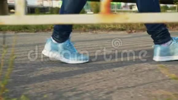 穿蓝色运动鞋和牛仔裤的儿童在户外散步视频的预览图