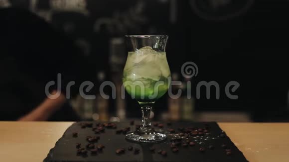 在一个带有咖啡豆的酒吧柜台上的新鲜莫吉托视频的预览图