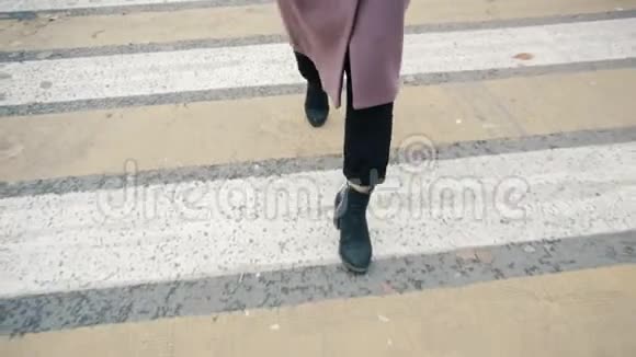 一个穿外套的女孩在行人过路处腿部特写视频的预览图