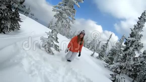 快乐美丽的少女滑雪者在雪中奔跑在雪松中跪倒在地扔雪花视频的预览图