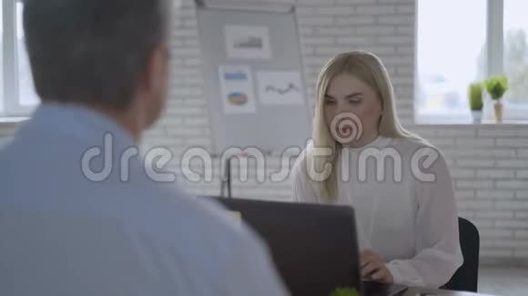 年轻成功的女老板在他的办公室采访一个男人商业成功的概念4K视频的预览图