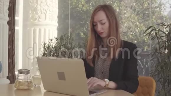 成年女商人在办公室里用笔记本电脑工作喝姜茶视频的预览图