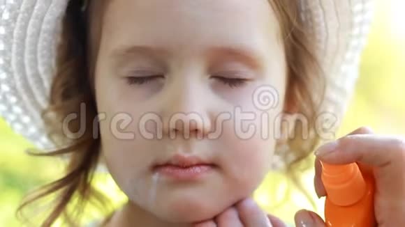 妈妈涂抹儿童脸太阳霜晒伤太阳奶油防晒霜特写女婴视频的预览图