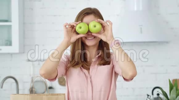 那个在白色厨房里的女孩正在玩绿苹果视频的预览图