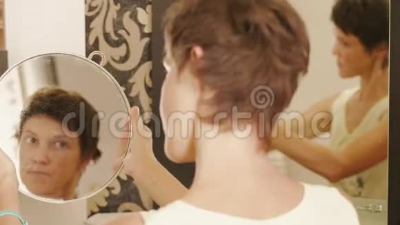 有镜子的女人理发后整理头发视频的预览图