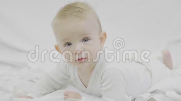 蓝眼睛的金发宝宝躺在床上看着相机催眠的眼神魅力视频的预览图