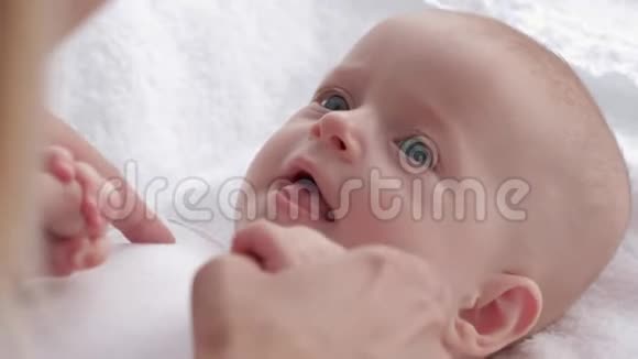 新生儿长着漂亮的眼睛看着妈妈伸出舌头父母和她的小女儿玩耍视频的预览图