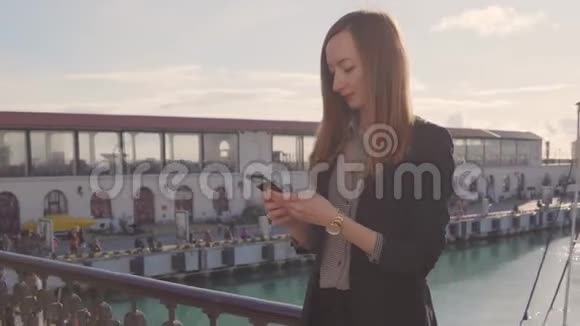 年轻女子带着智能手机在游艇港口水疗度假视频的预览图
