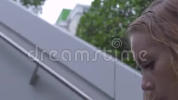 在现代城市公园里摇晃的射击脸年轻女子走上楼梯一个满脸卷曲的红头发的女人走过来视频的预览图
