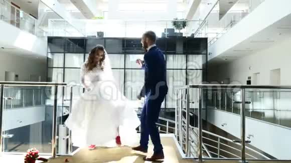 布鲁内特新娘和英俊的房间跳舞有趣的舞蹈在酒店大堂漂亮的新婚夫妇时髦的视频的预览图