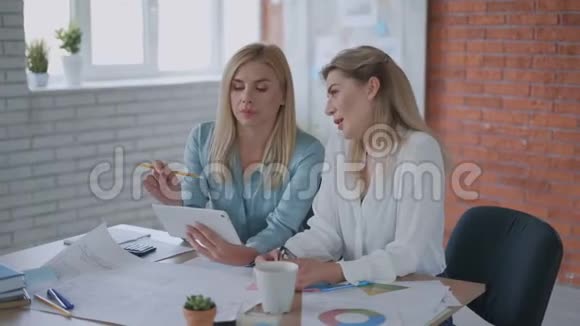 两名妇女正在从事一个项目女孩们在平板电脑上看报告现代办公团队合作理念4K视频的预览图