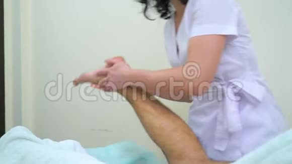女按摩师在温泉沙龙为男性顾客做足底按摩视频的预览图