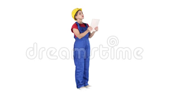 戴黄色安全帽的女工程师在检查白色建筑时正在看平板电脑视频的预览图