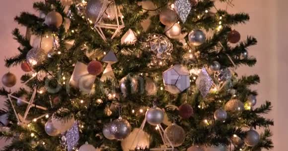 高大的圣诞树有花环装饰银星球和玩具在黑暗中视频的预览图