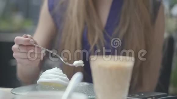 肖像美丽的黑发女人吃蛋糕与一个马卡龙在餐厅关闭性感的女人长着深深的乳沟视频的预览图