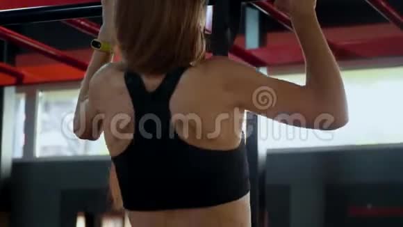 健身房里的年轻女孩把铁棍绑紧视频的预览图