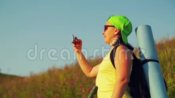 女徒步旅行者在山上背着背包双筒望远镜自拍视频的预览图