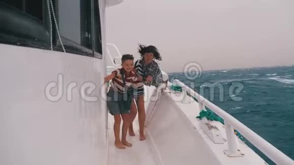 暴风雨中船上母亲和儿子的极端镜头视频的预览图