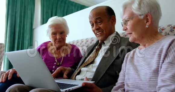 一群活跃的混血高级朋友在养老院讨论笔记本电脑视频的预览图