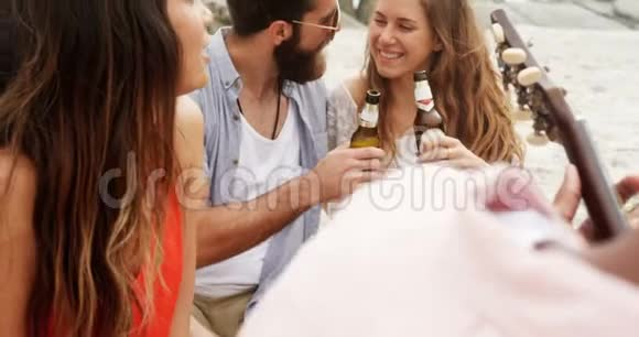 高加索夫妇在海滩上品尝啤酒瓶的正面景色视频的预览图