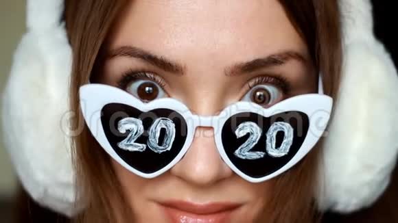 肖像特写女士戴太阳镜数字2020新年圣诞节女孩微笑着看着摄像机视频的预览图