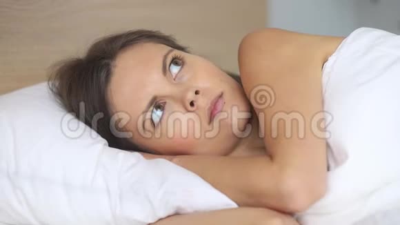 一个年轻的女人讨厌吵闹的邻居用枕头捂住耳朵视频的预览图